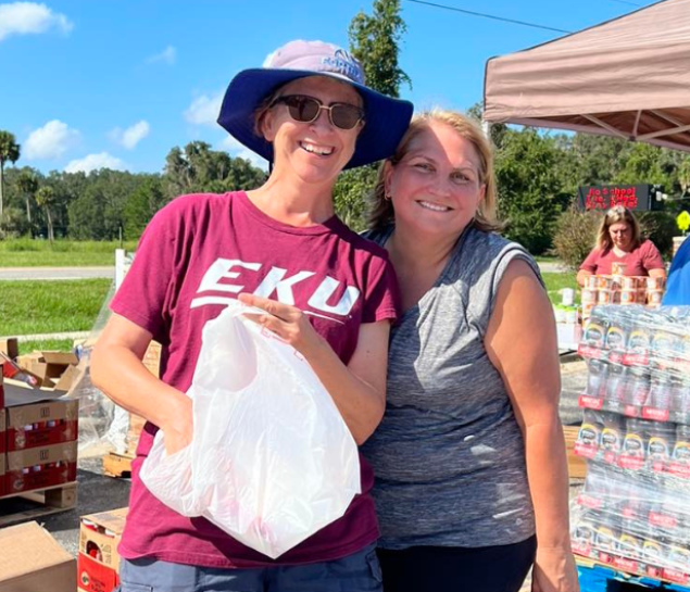 Two female volunteers handing out disaster supplies