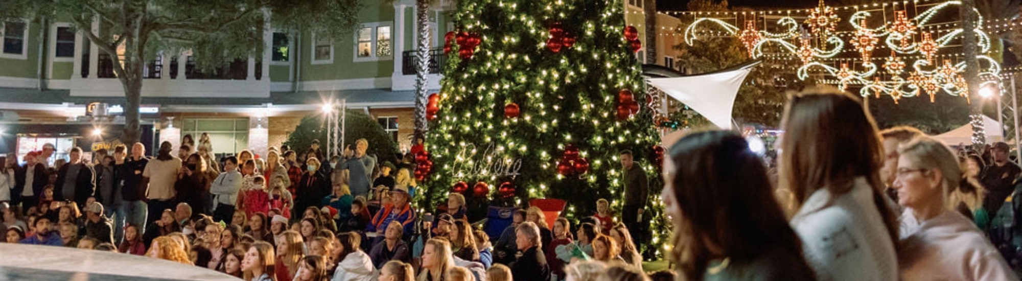 Photograph of Christmas Tree with people standing around